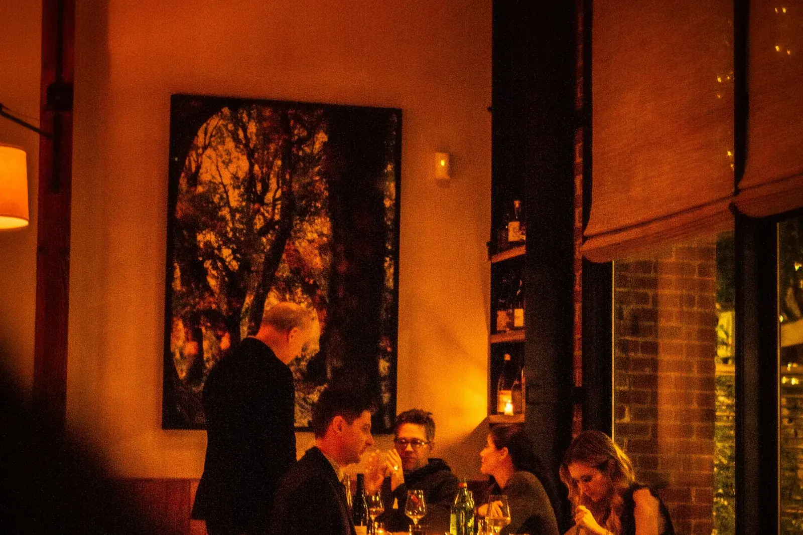 Guests dining in a warm, low lit restaurant room